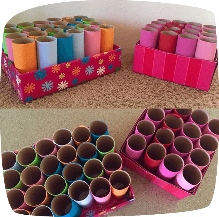 DIY organizer boxes made from decorated cardboard boxes filled with colorful painted toilet paper rolls standing upright.